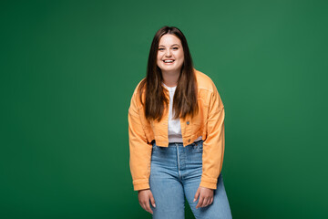 Positive plus size woman looking at camera isolated on green
