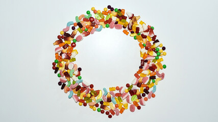 Flatlay of colorful sweets, jelly candies made from fruit juice, gelatin and sugar lying in the shape of circle isolated over white background