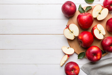 Fresh red apples with green leaves on table. cutting board with knife. Top view