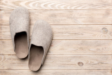 Warm winter women woolen slippers on the floor. Copy space for text - obrazy, fototapety, plakaty