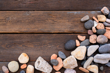 Sea pebbles on the wooden board flat lay background with copy space.