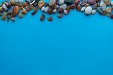 Flat lay composition sea pebbles on a blue background. space for text