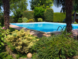outdoor summer pool with blue water in the garden