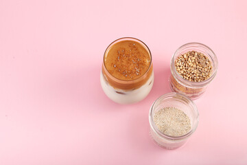 Dalgona Misugaru Latte - Korean refreshing drink. Popular breakfast drink with instant coffee. Pink background, copy space