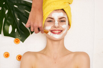 cheerful woman with a towel on my head skin care light background