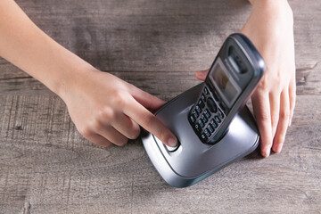 woman dials the number on home phone