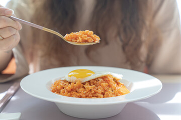 Kimchi fried rice with eggs and a spoon with kimchi fried rice.