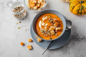 Vegetarian autumn pumpkin soup with cream, seeds and toasts. Autumn and winter healthy food concept.