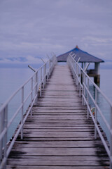 Fototapeta premium Using a wide aperture, the camera was focused in the middle of the foot bridge that connects the shoreline to the cottage in the middle of the sea.