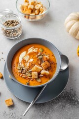 Vegetarian autumn pumpkin soup with cream, seeds and toasts. Autumn and winter healthy food concept.