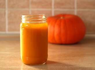 baby pumpkin puree with fresh pumpkin on beige background