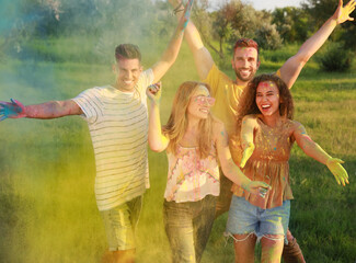 Fototapeta premium Happy friends having fun with colorful powder dyes outdoors. Holi festival celebration