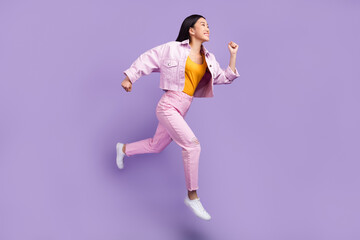Full length profile photo of funny young brunette lady run wear jacket jeans sneakers isolated on violet background - Powered by Adobe