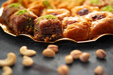 Delicious baklava dessert in oriental setting on black background