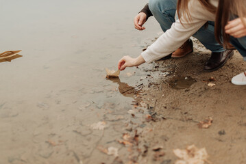 paper boat close-up man and woman launch paper boat on water