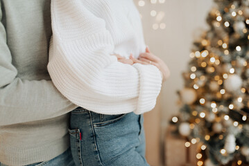 young couple hugging on the background of the christmas tree