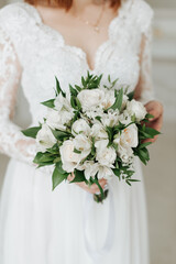 bride in a white dress with a beautiful wedding bouquet in her hands close-up