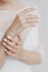 hands of the bride in a white wedding dress close up