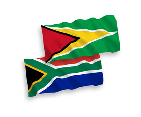 National vector fabric wave flags of Co-operative Republic of Guyana and Republic of South Africa isolated on white background. 1 to 2 proportion.