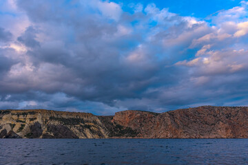 rocks of Cape Fiolent against the background of the evening sky with clouds