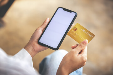 female hand holding phone and credit card