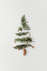 Christmas tree made of leaves, branches and berries. New Year or holiday concept. Minimal flat lay creative idea.