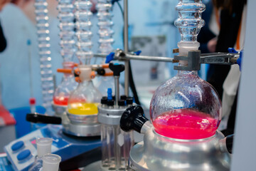 Laboratory equipment - glass flask with multicolored liquid on heating mantle. Chemistry, science, pharmaceutical, lab equipment concept