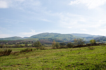 beautiful panorama of early autumn. rural fields against the backdrop of mountains. green field and blue mountains