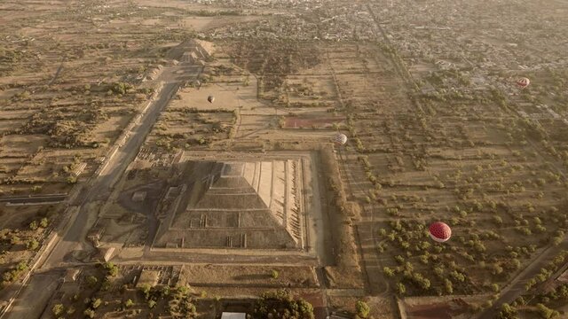 Beautiful aerial view of Pyramid of the Sun with sunrise and air balloons in  Teotihuacan, Mexico.