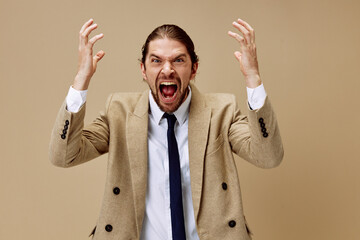 handsome man in a suit with a tie posing beige background