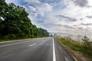 Fototapeta na wymiar dramatic landscape. morning in the mountains. fog in the background. landscape of early autumn. road to the mountains