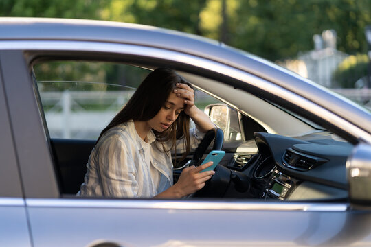 Frustrated Girl Cry Reading Sms Message In Smartphone While Driving Car. Upset Young Female Break Up With Boyfriend In Traffic Jam Getting Bad News In Mobile Phone. Unhappy Sad Woman Driver In Tears