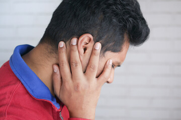 Fototapeta premium young man having ear pain touching his painful ear ,