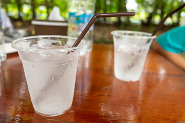 A clear plastic tumbler full of water and ice.