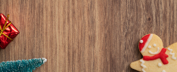 Decorated Christmas gingerbread cookies with decorations on wooden table background.