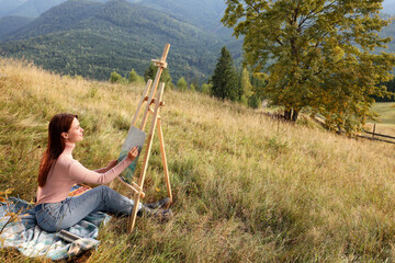 Young woman drawing landscape with soft pastels in nature. Space for text