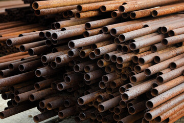 Many small-diameter metal pipes for gasification and construction lie in a stack in an open...