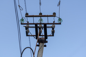 Electric pole with wires on a background of blue sky.