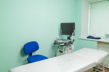 empty medical office with ultrasound machine and white couch.