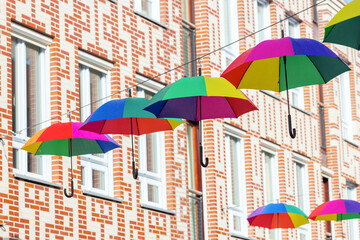 city street with rainbow colored umbrellas at a line in Nijmegen, Netherlands