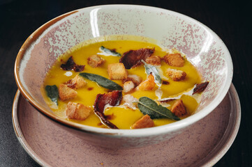 Tasty pumpkin cream soup with prawns and croutons.