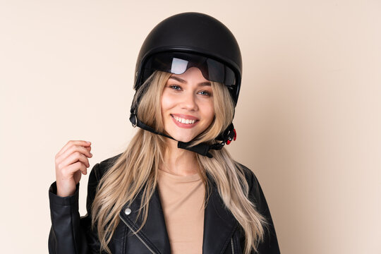 Russian girl with a motorcycle helmet isolated on beige background