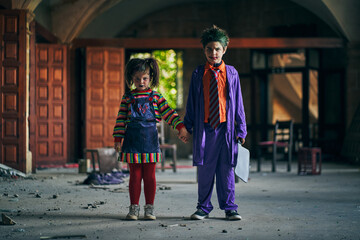 Serious kids in villains costumes in abandoned house