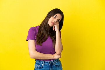 Young caucasian woman isolated on yellow background with tired and bored expression