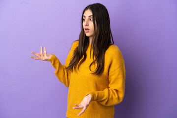 Young caucasian woman isolated on purple background with surprise expression while looking side