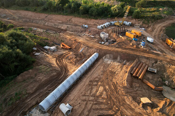 Concrete sewer pipes for laying external sewage system at construction site. Tunnel boring machine...