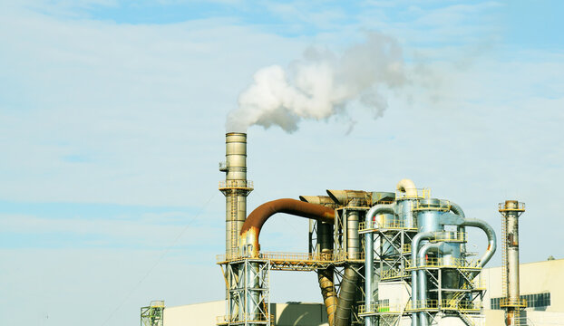 Refinery plant with pipes. Smoke tower of industrial factory CHP. Chimney smokestack emission. Plant with smoke frow pipe and environmental pollution. Ecology concept and poor environment.
