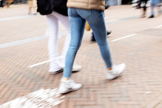 picture with camera made motion blur effect of legs of a couple walking on a shopping street