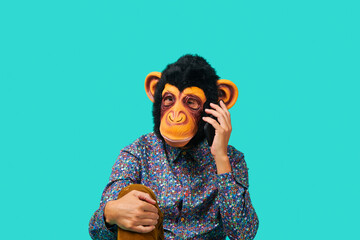 man wearing a monkey mask talking on the phone