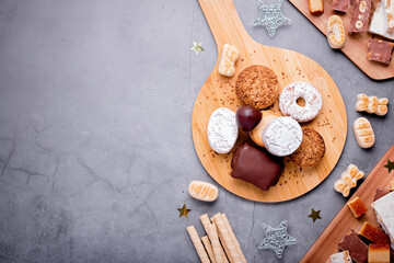 Traditional Spanish Christmas sweets turron, polvorones, mantecados with Christmas decor on grey...